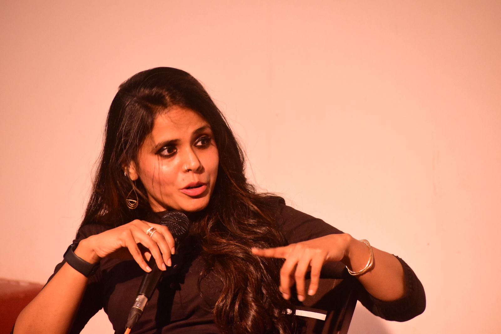 Meena Kandasamy speaking into a microphone at a literary event